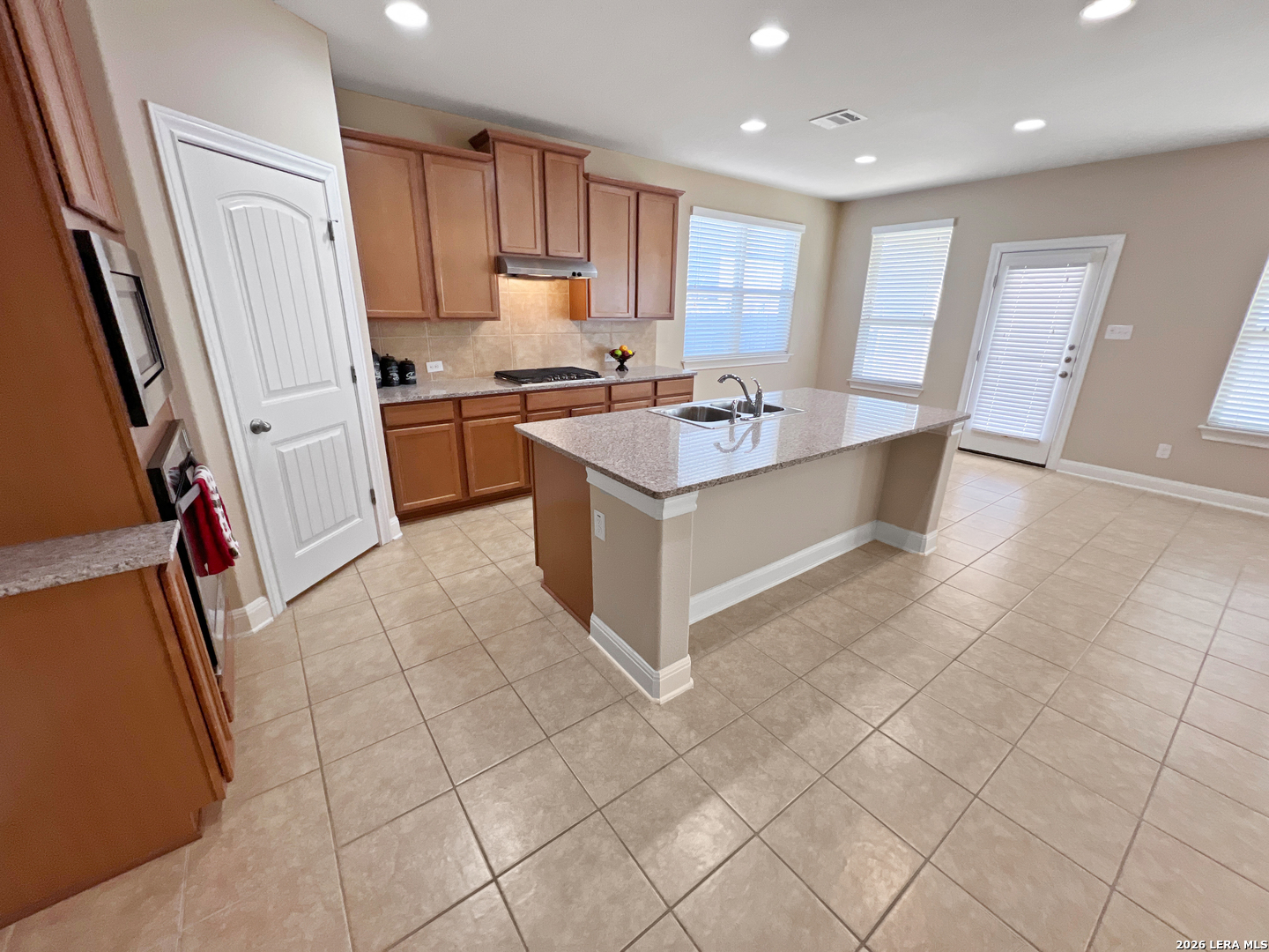 8626 Jogeva Rise San Antonio, TX 78251 - Photo 23 of 44 a kitchen with stainless steel appliances a stove a sink a microwave a refrigerator and cabinets