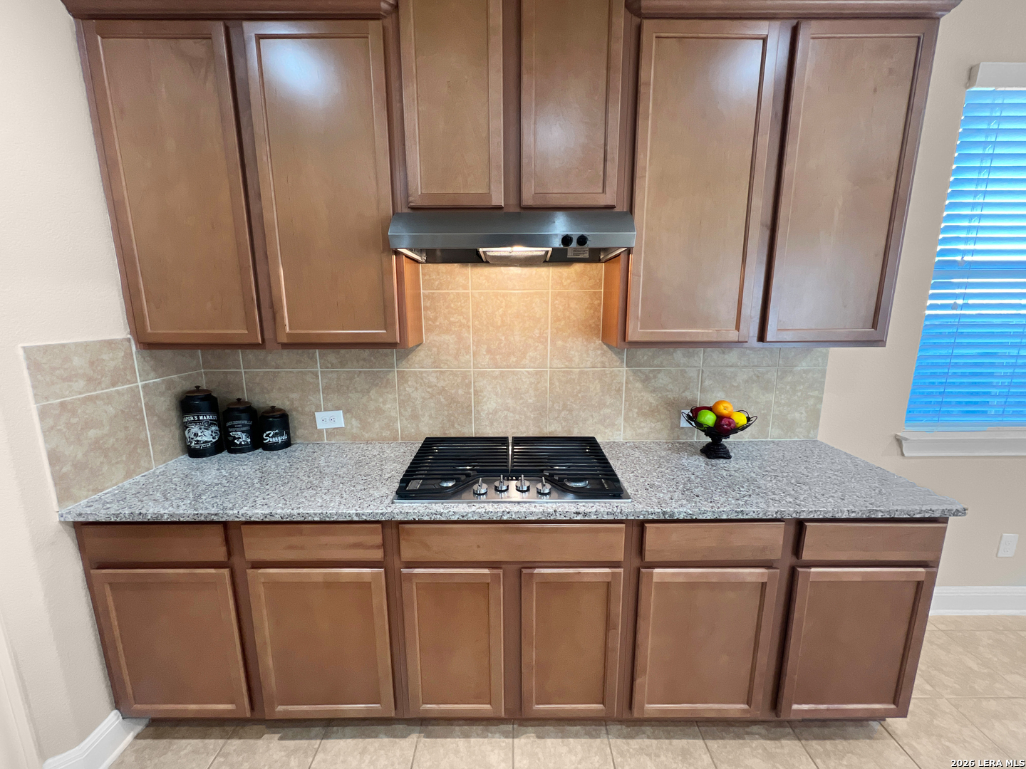 8626 Jogeva Rise San Antonio, TX 78251 - Photo 25 of 44 a kitchen with granite countertop cabinets and white appliances