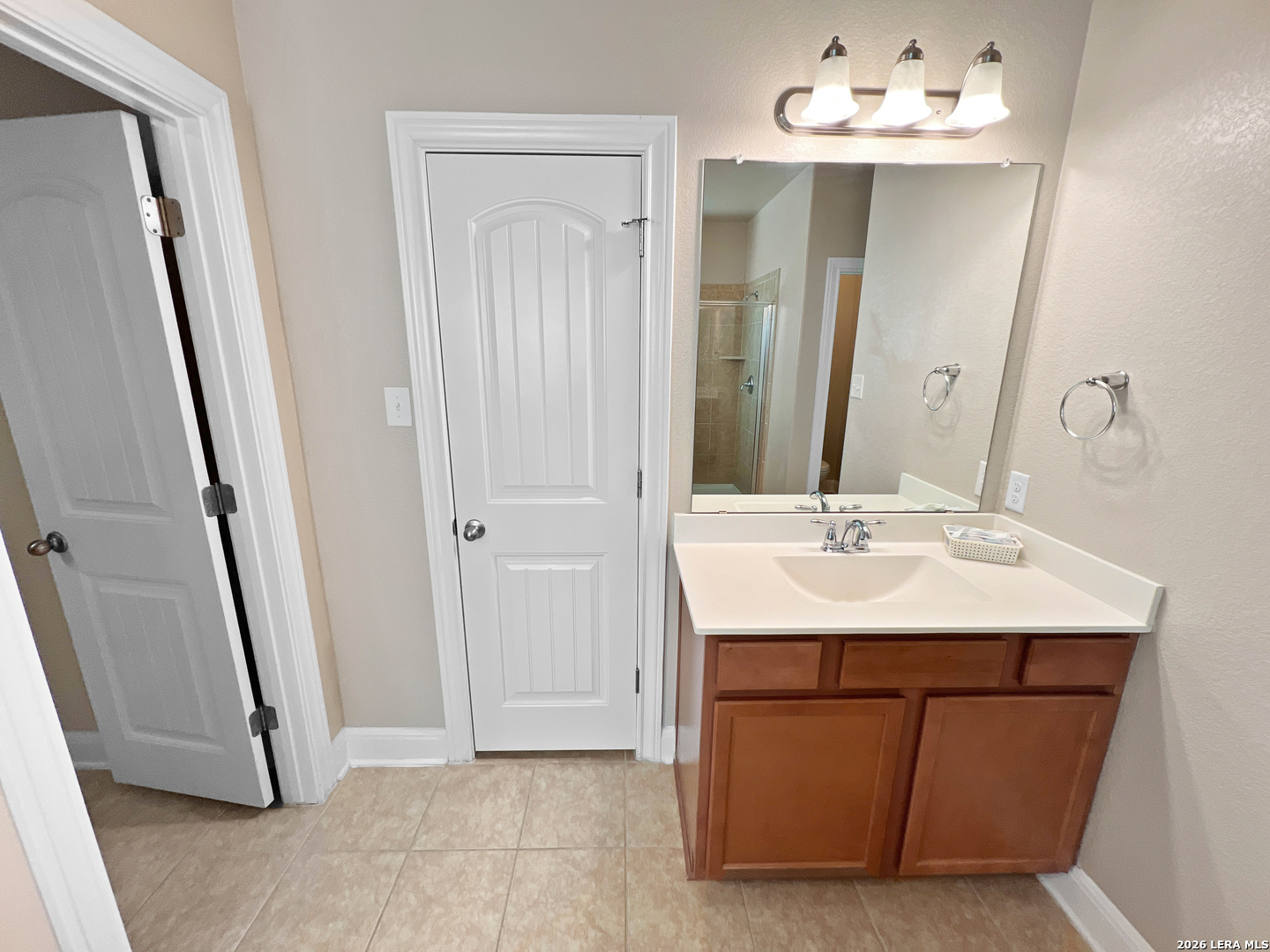 8626 Jogeva Rise San Antonio, TX 78251 - Photo 37 of 44 a bathroom with a sink a mirror and a shower