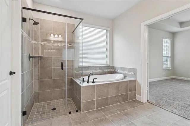a bathroom with a tub shower and a sink