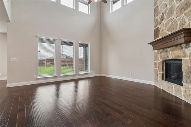 a view of wooden floor fireplace and windows in an empty room