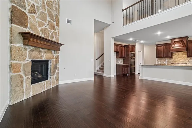 a view of a kitchen with a fridge wooden floor and a kitchen