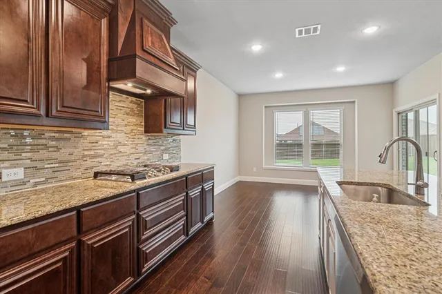 a kitchen with granite countertop wooden cabinets granite counter tops and a stove