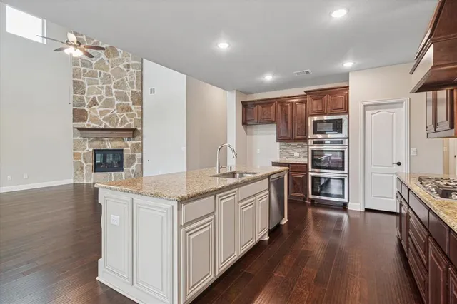 a kitchen with stainless steel appliances kitchen island granite countertop a stove and a refrigerator