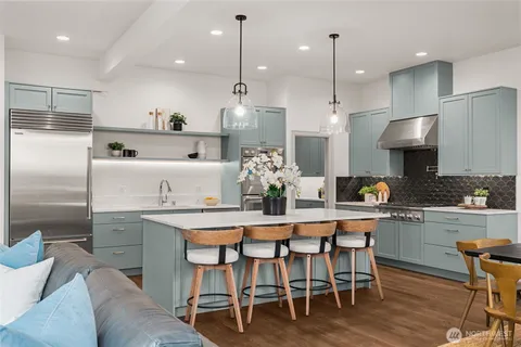 a kitchen with kitchen island stainless steel appliances a dining table and chairs