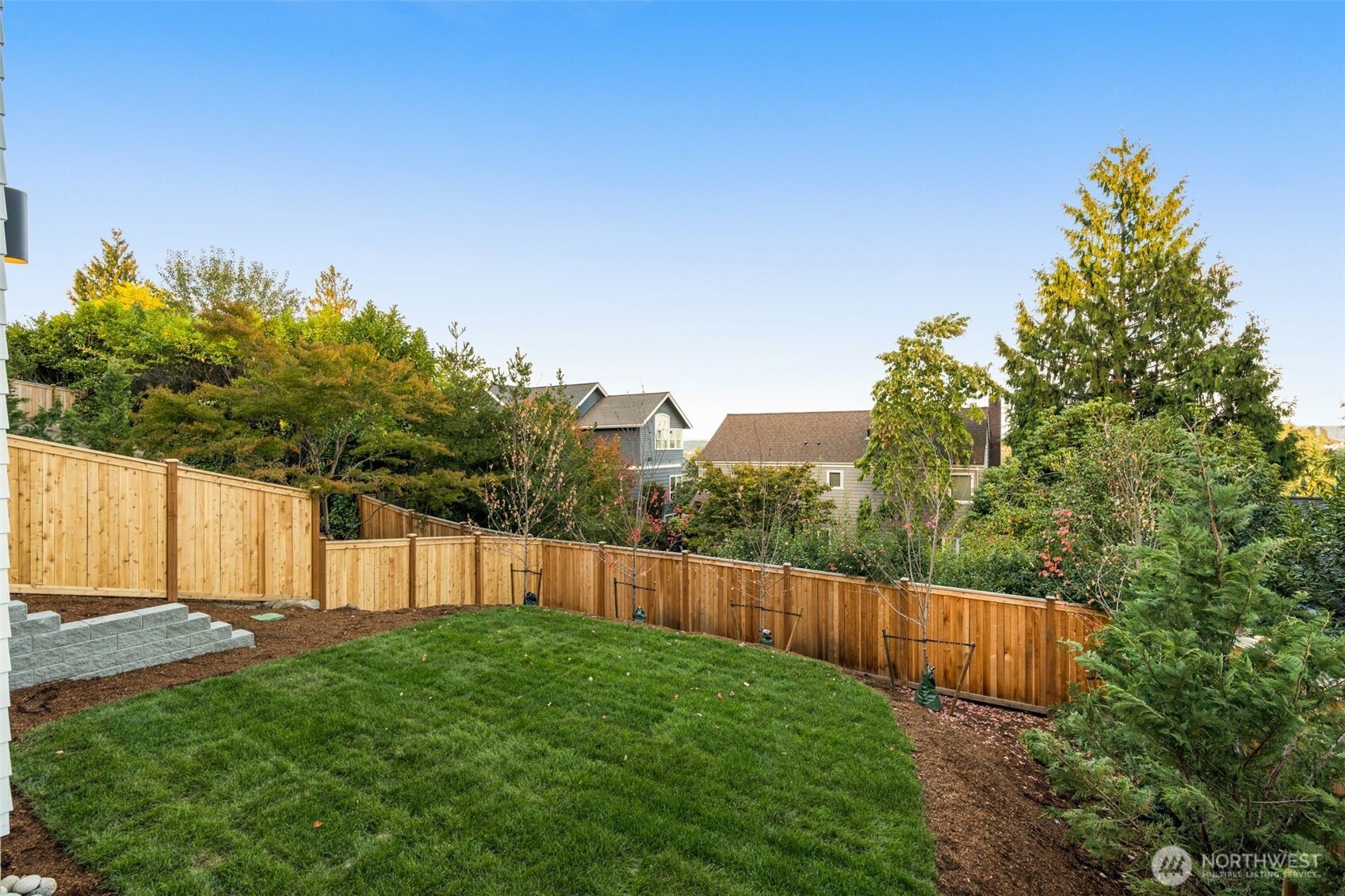 6032 50th Avenue Northeast Seattle, WA 98115 - Photo 36 of 40 a view of a backyard with large trees and wooden fence