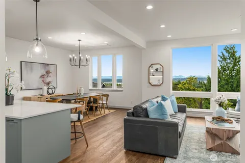 a living room with furniture kitchen view and a large window