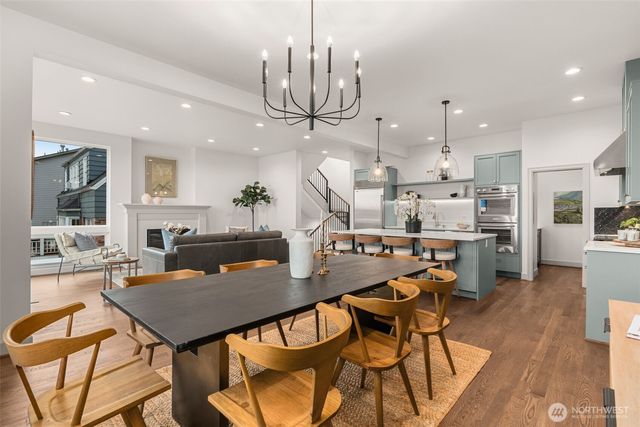 a view of a dining room with furniture a kitchen and chandelier