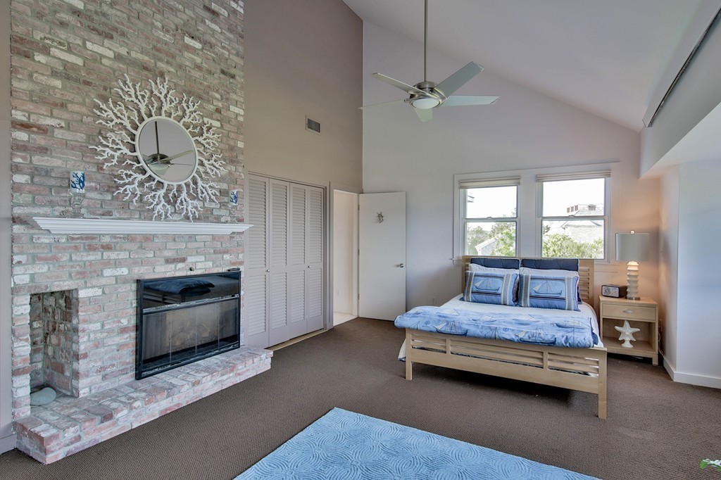 139-138 Atlantic Road Gloucester, MA 01930 - Photo 20 of 28 a bedroom with a bed and a fireplace