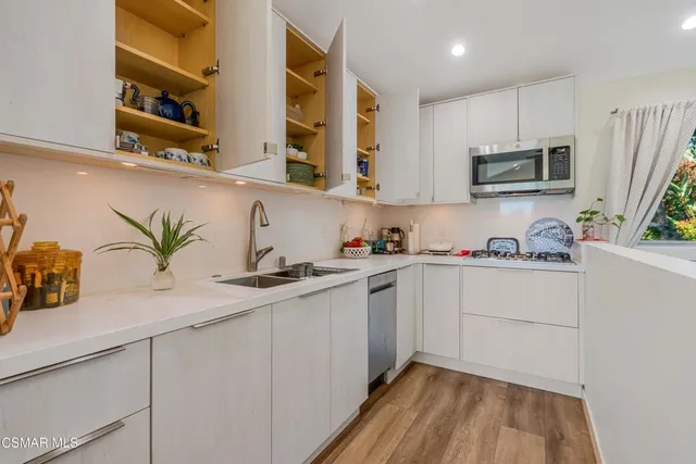 a kitchen with stainless steel appliances granite countertop a sink a stove and cabinets