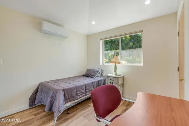 a bedroom with a bed chair and window