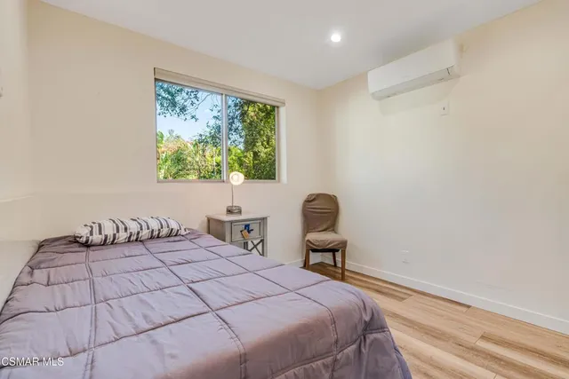 a bedroom with a bed and a painting on the wall