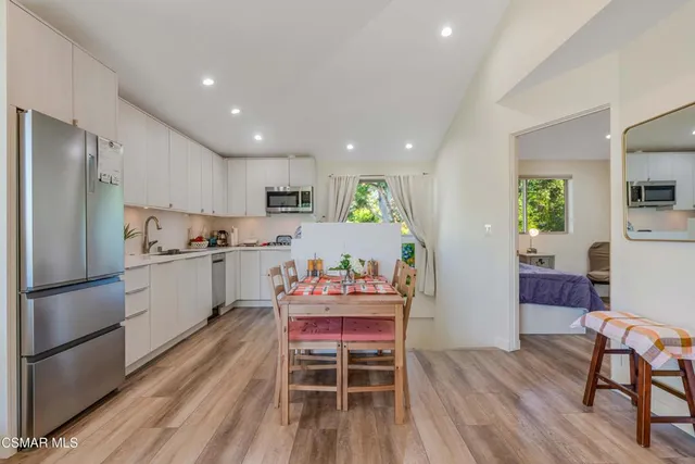 a kitchen with a table chairs refrigerator and microwave