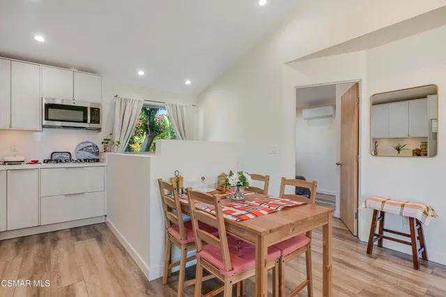 a kitchen with kitchen island a stove a table and chairs in it