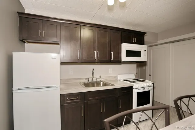 a kitchen with stainless steel appliances a stove microwave and sink