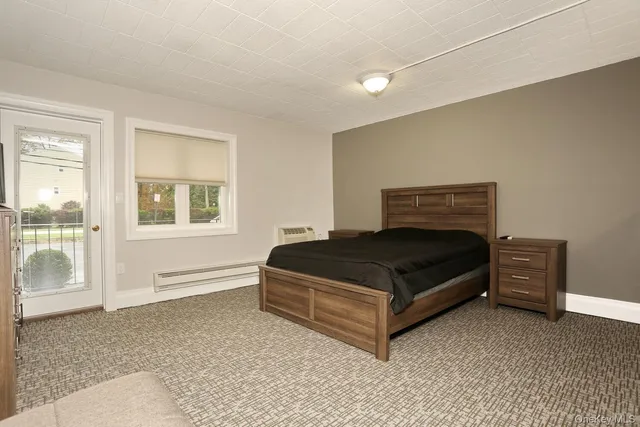 a bedroom with a bed lamp and a large window