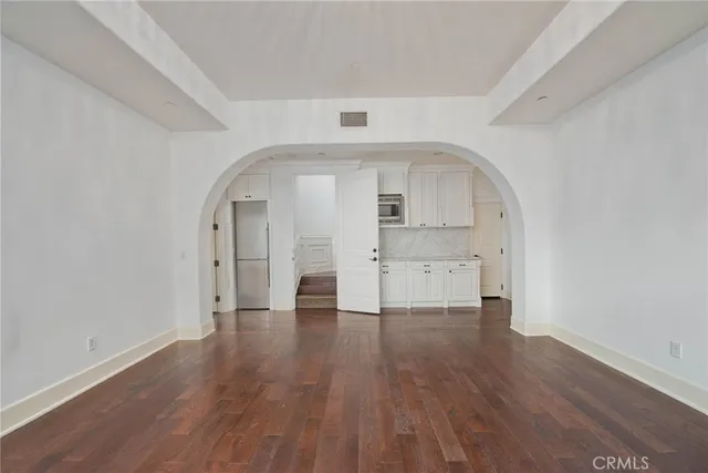an empty room with wooden floor and a window