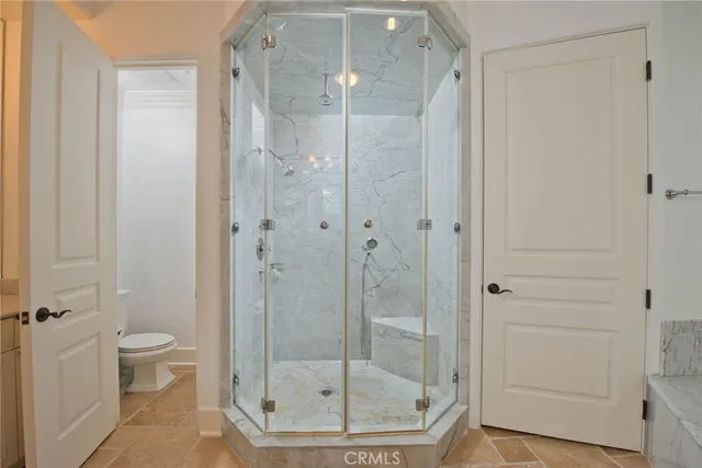 a bathroom with a granite countertop sink a toilet a mirror and shower