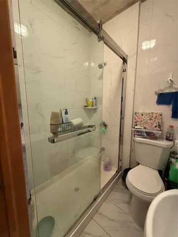 a bathroom with a toilet and a shower