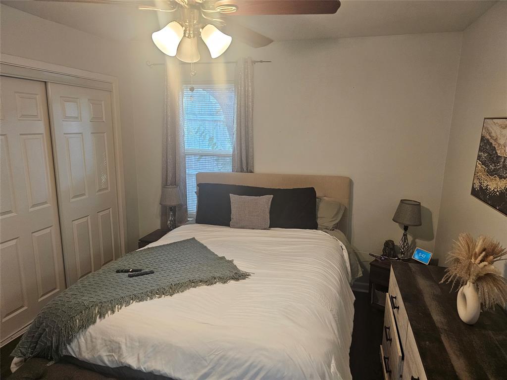 9911 Ferguson Road Dallas, TX 75228 - Photo 13 of 18 a bedroom with a bed and a chandelier