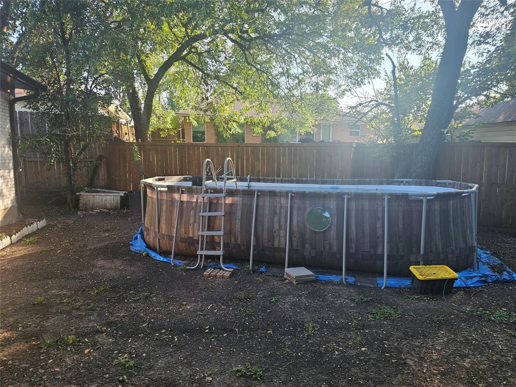 9911 Ferguson Road Dallas, TX 75228 - Photo 18 of 18 a view of a backyard with a small cabin and a chair