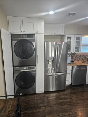 a kitchen with a refrigerator sink and cabinets