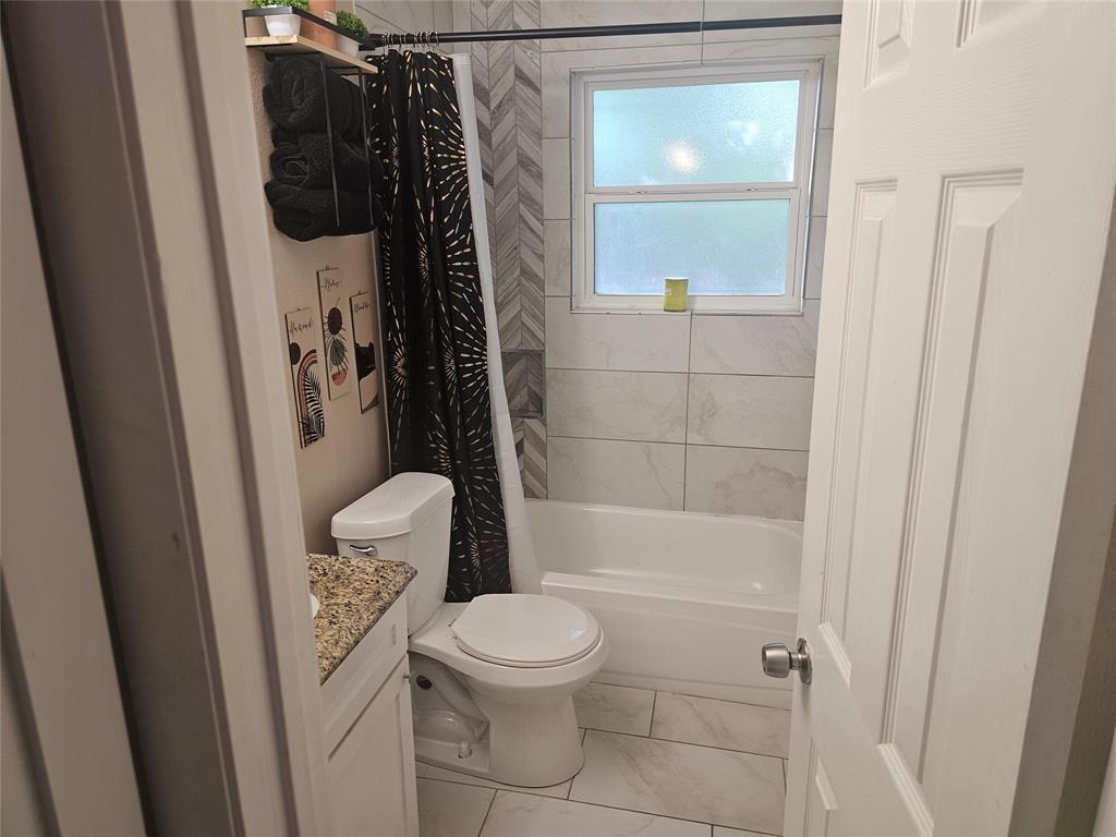 9911 Ferguson Road Dallas, TX 75228 - Photo 9 of 18 a bathroom with a toilet and a shower