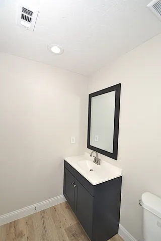 a bathroom with a sink mirror and toilet