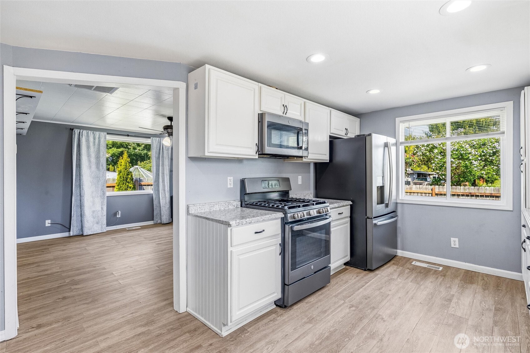 113 South Gardner Road Burlington, WA 98233 - Photo 4 of 40 a kitchen with stainless steel appliances granite countertop a stove a refrigerator a microwave a sink and white cabinets with wooden floor
