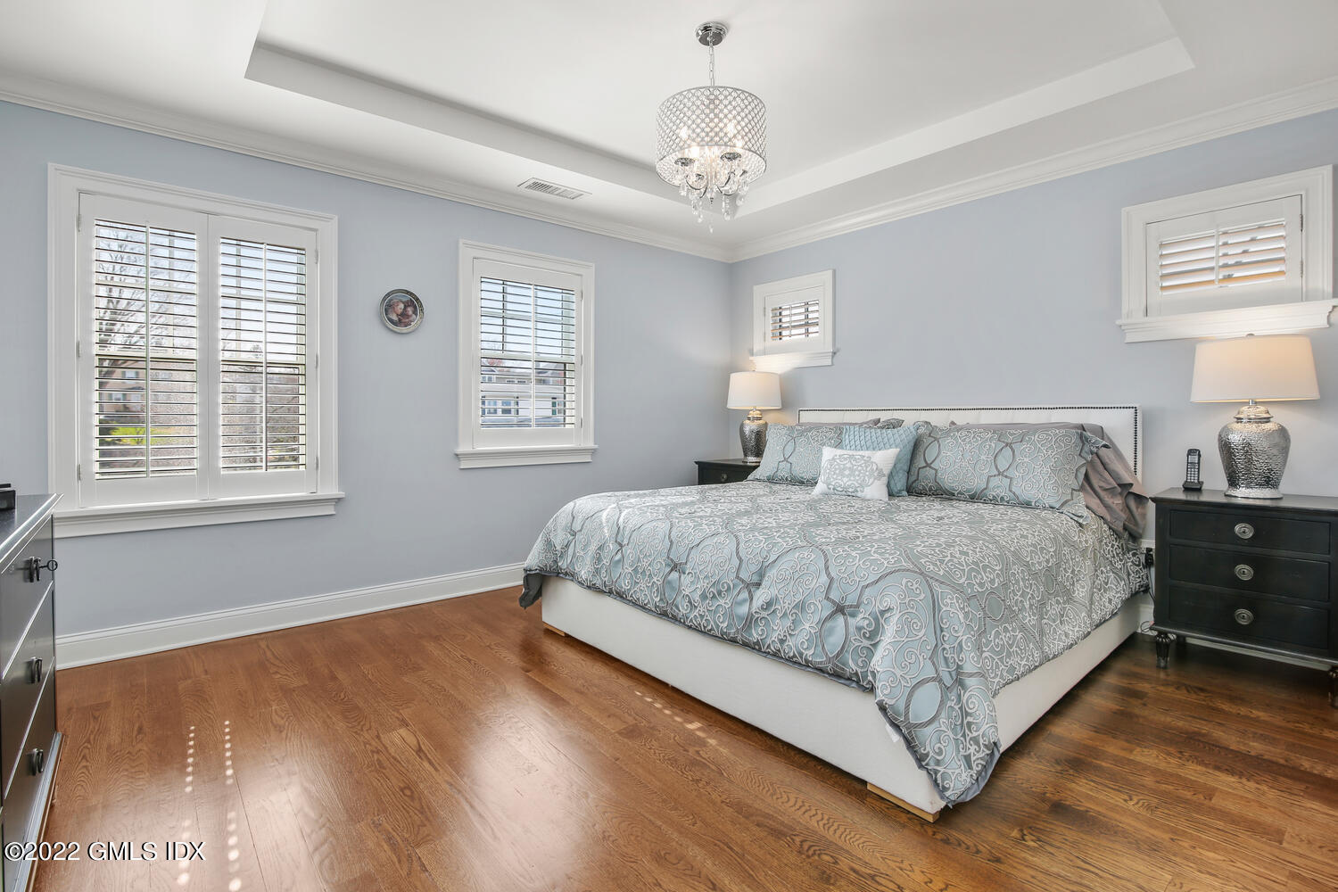 24 Harold Street, Unit C Cos Cob, CT 06807 - Photo 16 of 32 a bedroom with a large bed chandelier and windows