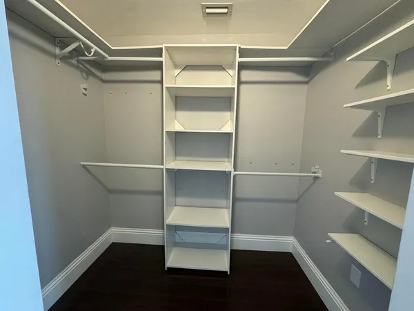 a view of walk in closet with empty racks
