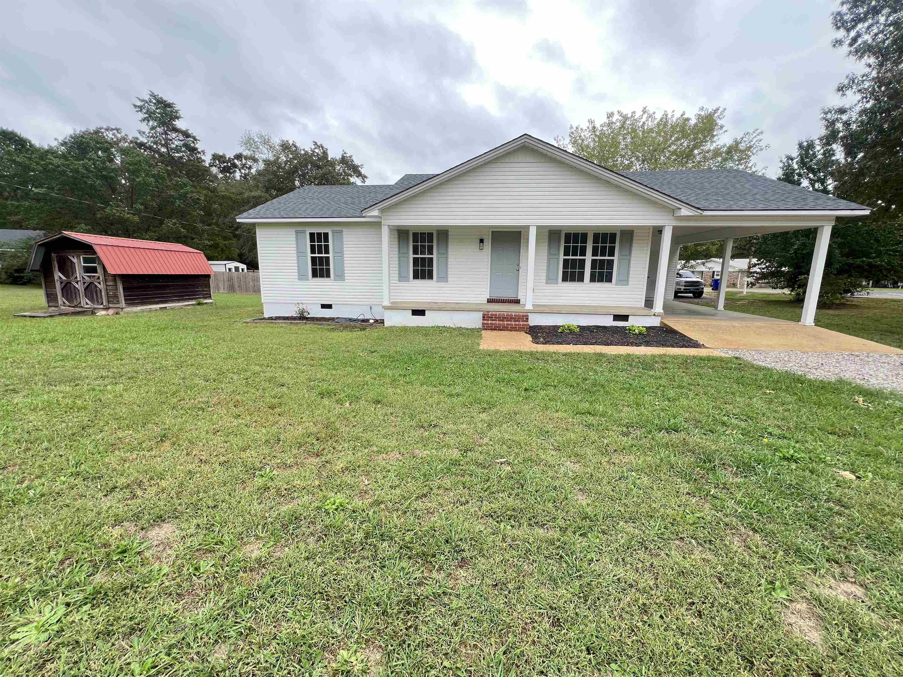 1250 Clifton Road Savannah, TN 38372 - Photo 1 of 33 View of front of house with crawl space, a porch, gravel driveway, an attached carport, and a front lawn