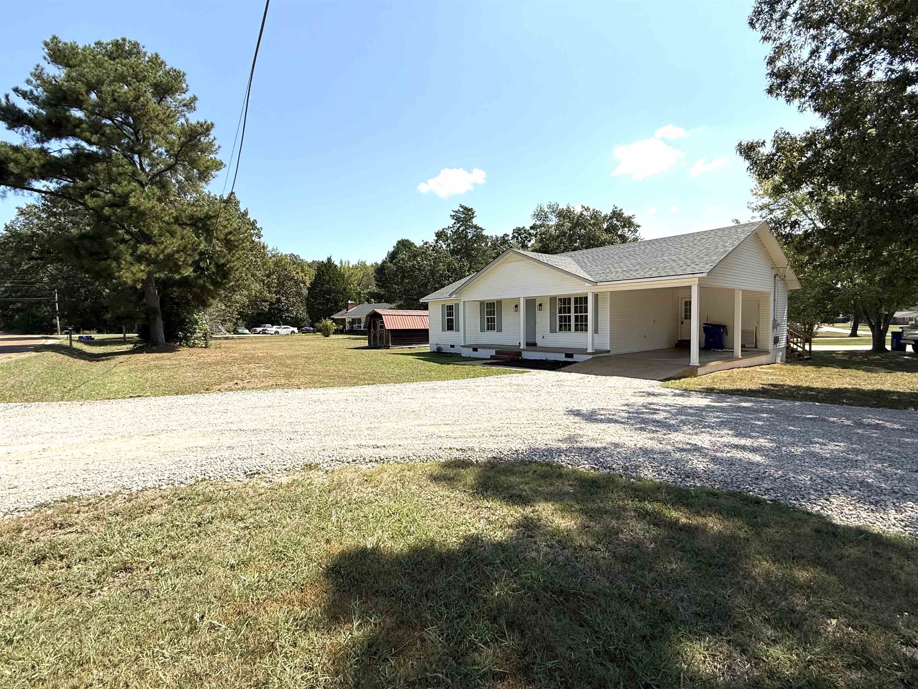 1250 Clifton Road Savannah, TN 38372 - Photo 23 of 33 View of front facade with driveway, a carport, a front lawn, roof with shingles, and covered porch
