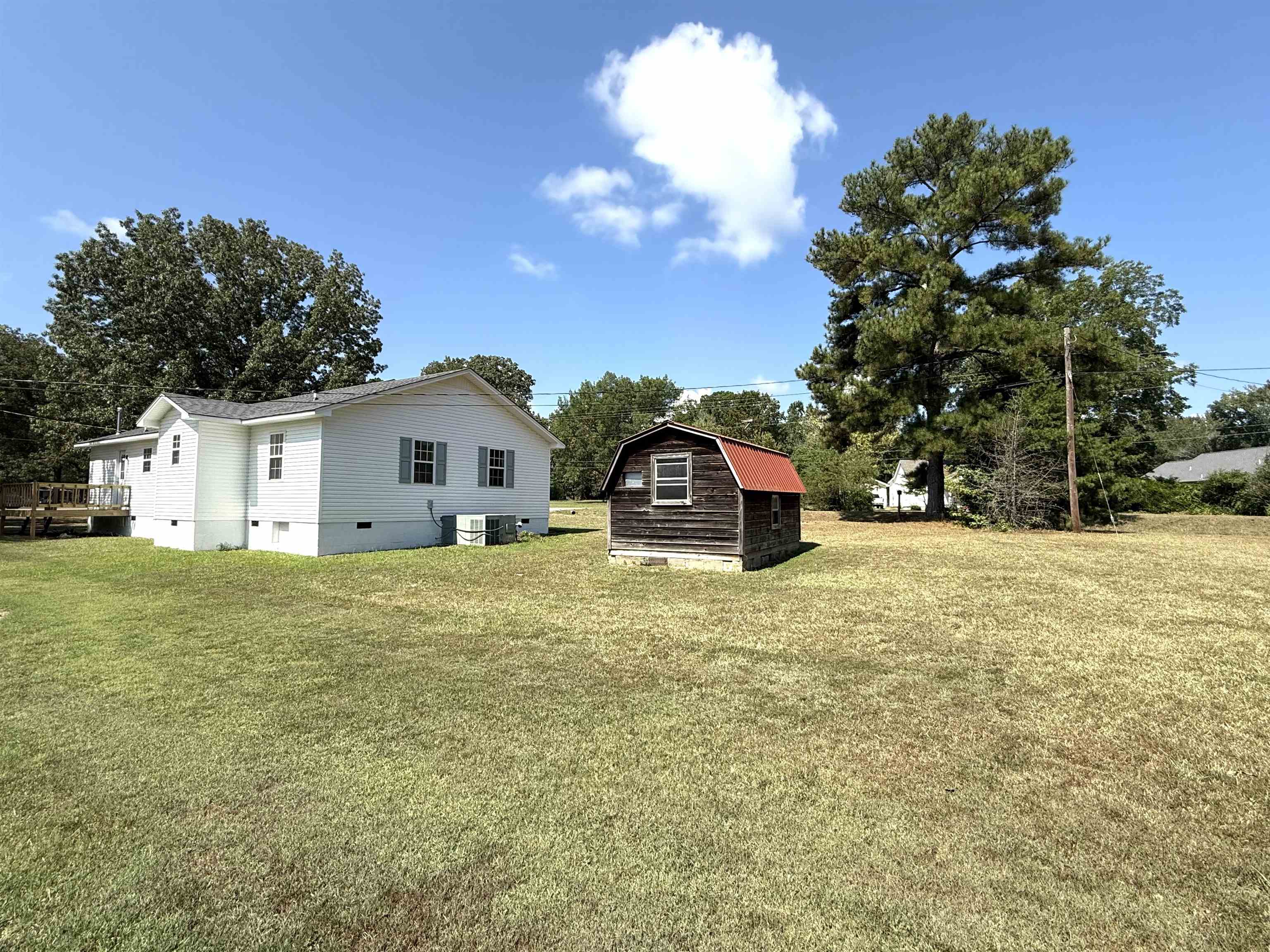 1250 Clifton Road Savannah, TN 38372 - Photo 24 of 33 View of grassy yard featuring a deck and a storage shed