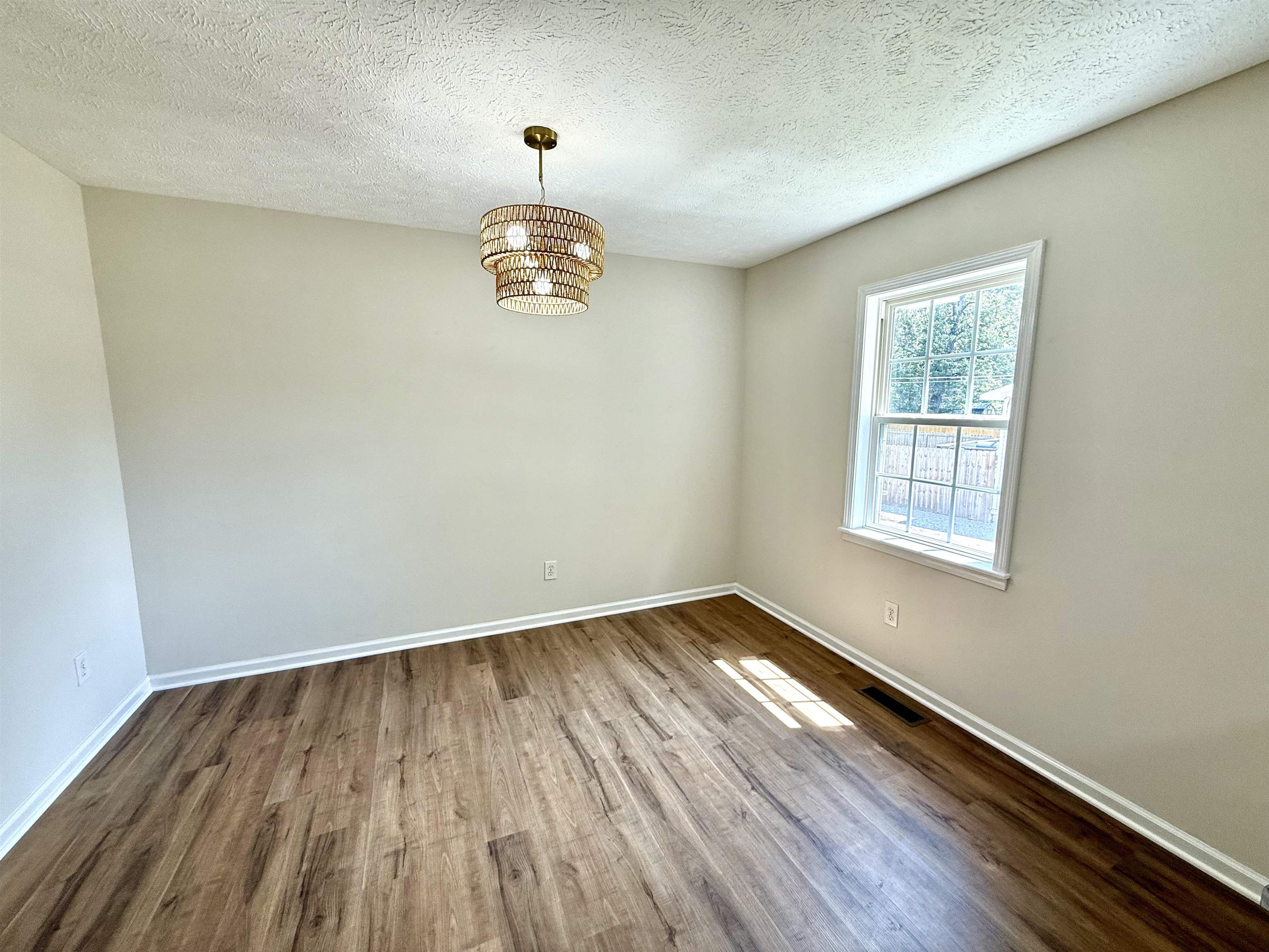1250 Clifton Road Savannah, TN 38372 - Photo 6 of 33 Unfurnished dining area featuring a textured ceiling, dark wood finished floors, and a chandelier