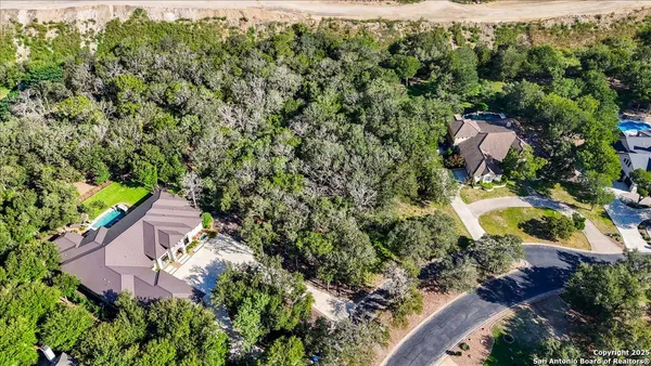 an aerial view of a house with a yard and lake view