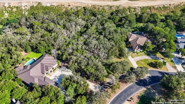 an aerial view of a house with a yard and lake view