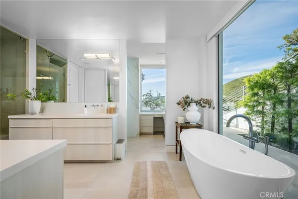 a bathroom with a white tub shower vanity and a sink