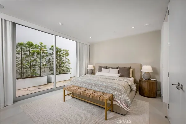 a spacious bedroom with a bed and a large window