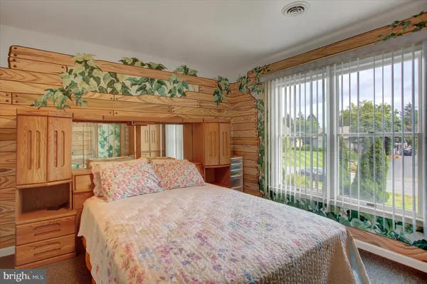 a bedroom with a large bed a window and dresser
