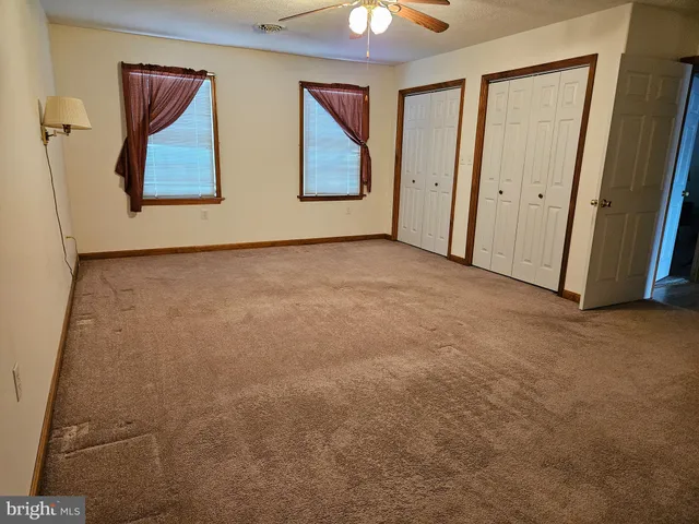 an empty room with windows and cabinet