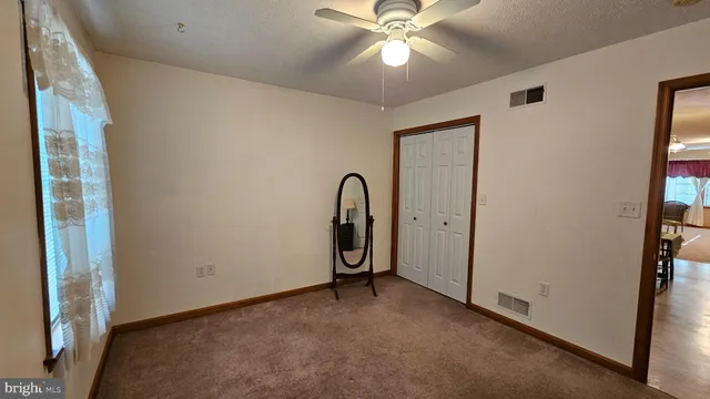 a view of a room with a ceiling fan and window