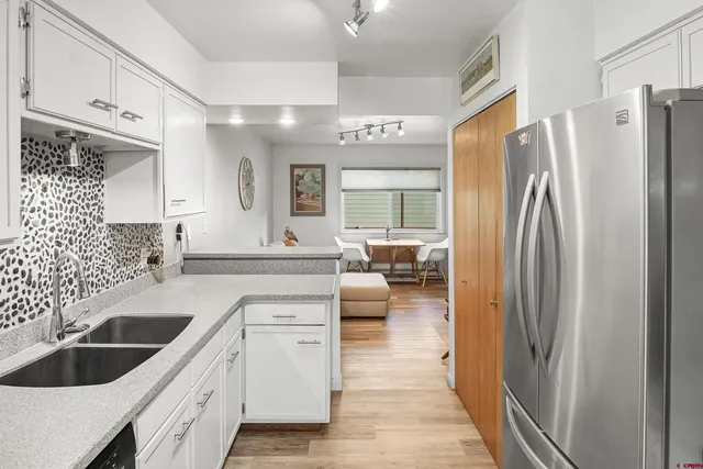 a kitchen with white cabinets and refrigerator