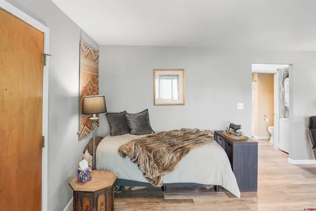 a bedroom with a bed and wooden floor