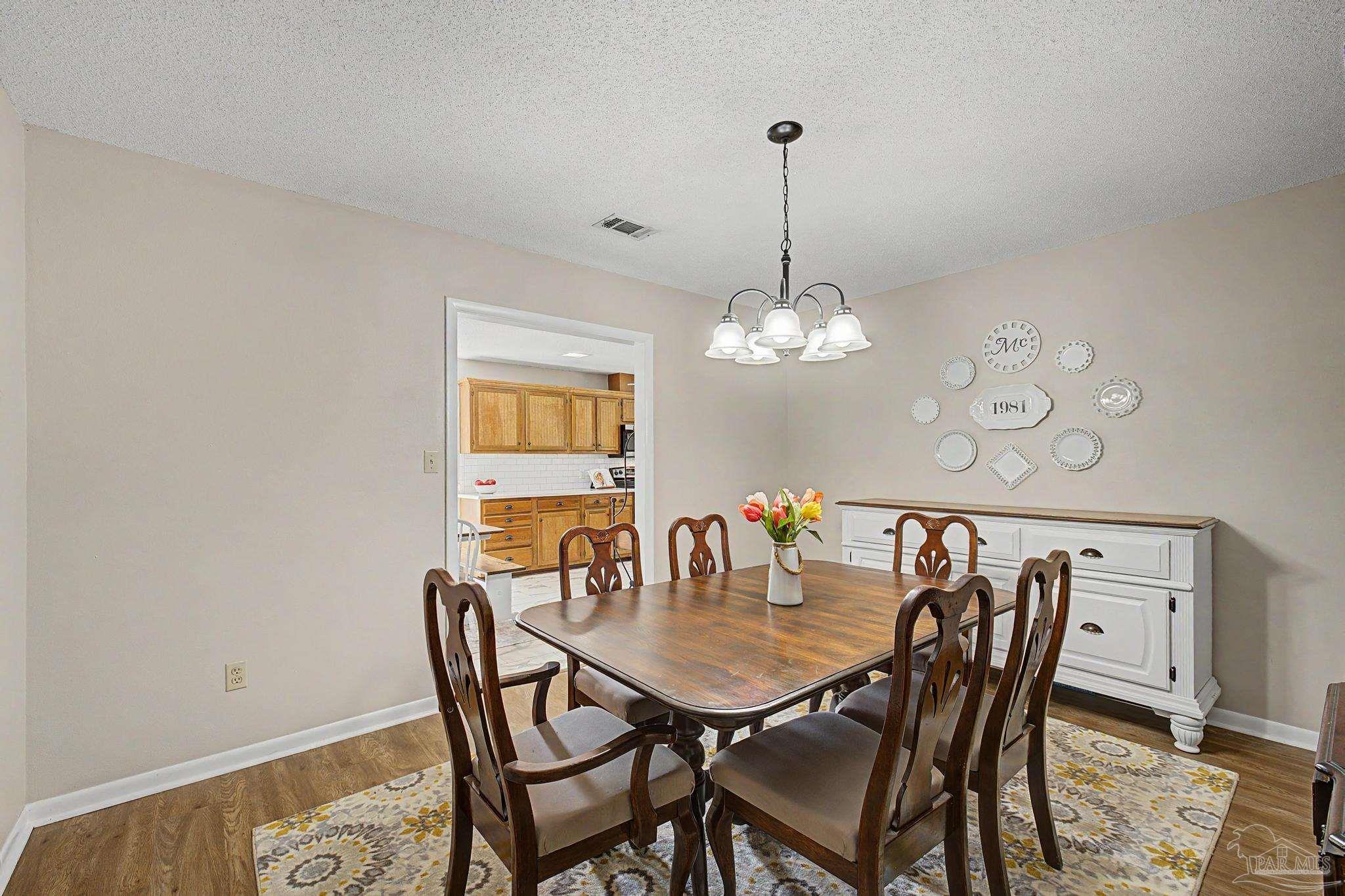4959 Skipper Lane Pace, FL 32571 - Photo 16 of 51 a view of a dining room with furniture and chandelier