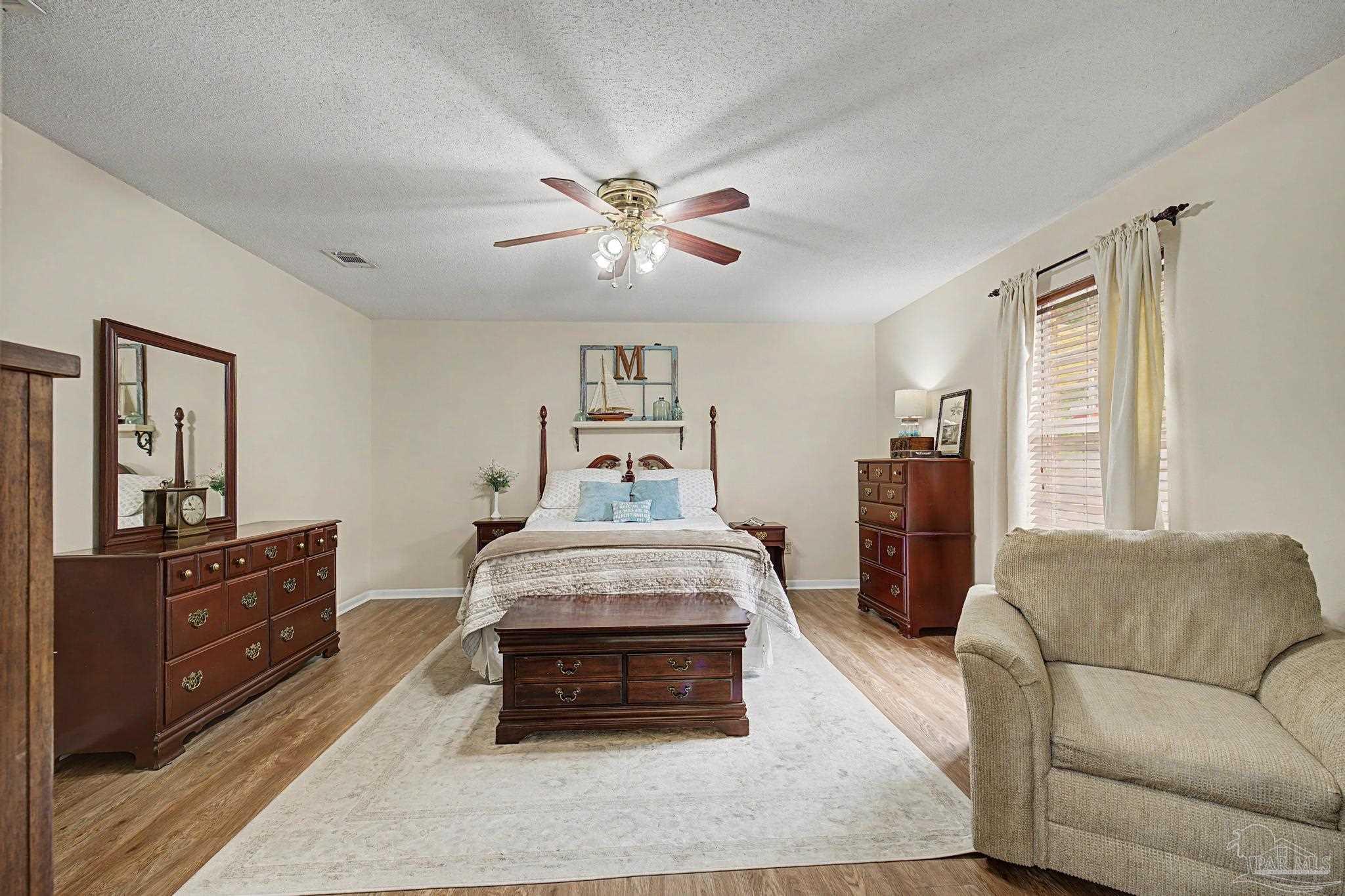 4959 Skipper Lane Pace, FL 32571 - Photo 19 of 51 a bedroom with a bed and wooden floor
