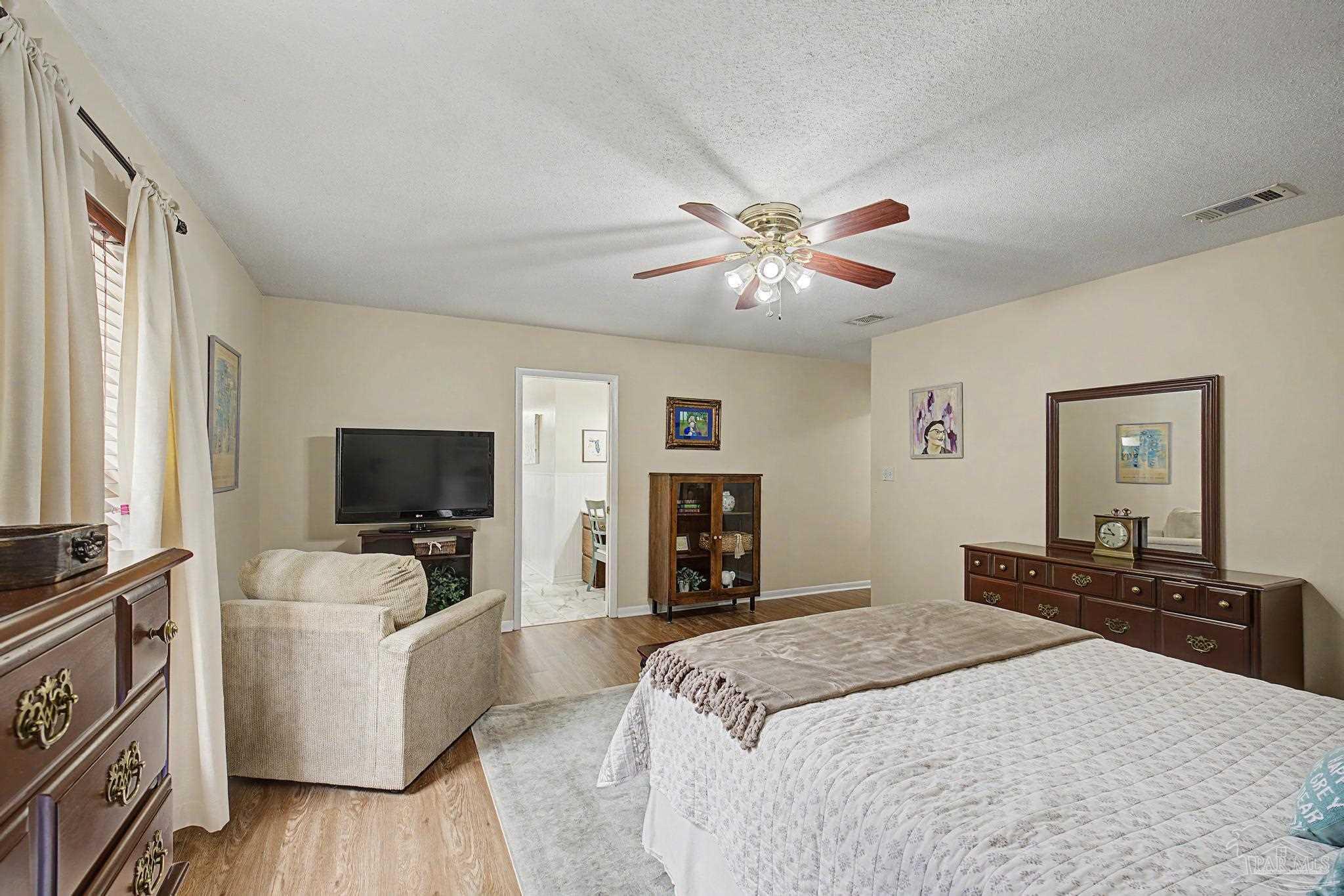 4959 Skipper Lane Pace, FL 32571 - Photo 20 of 51 a bedroom with a bed and a flat screen tv
