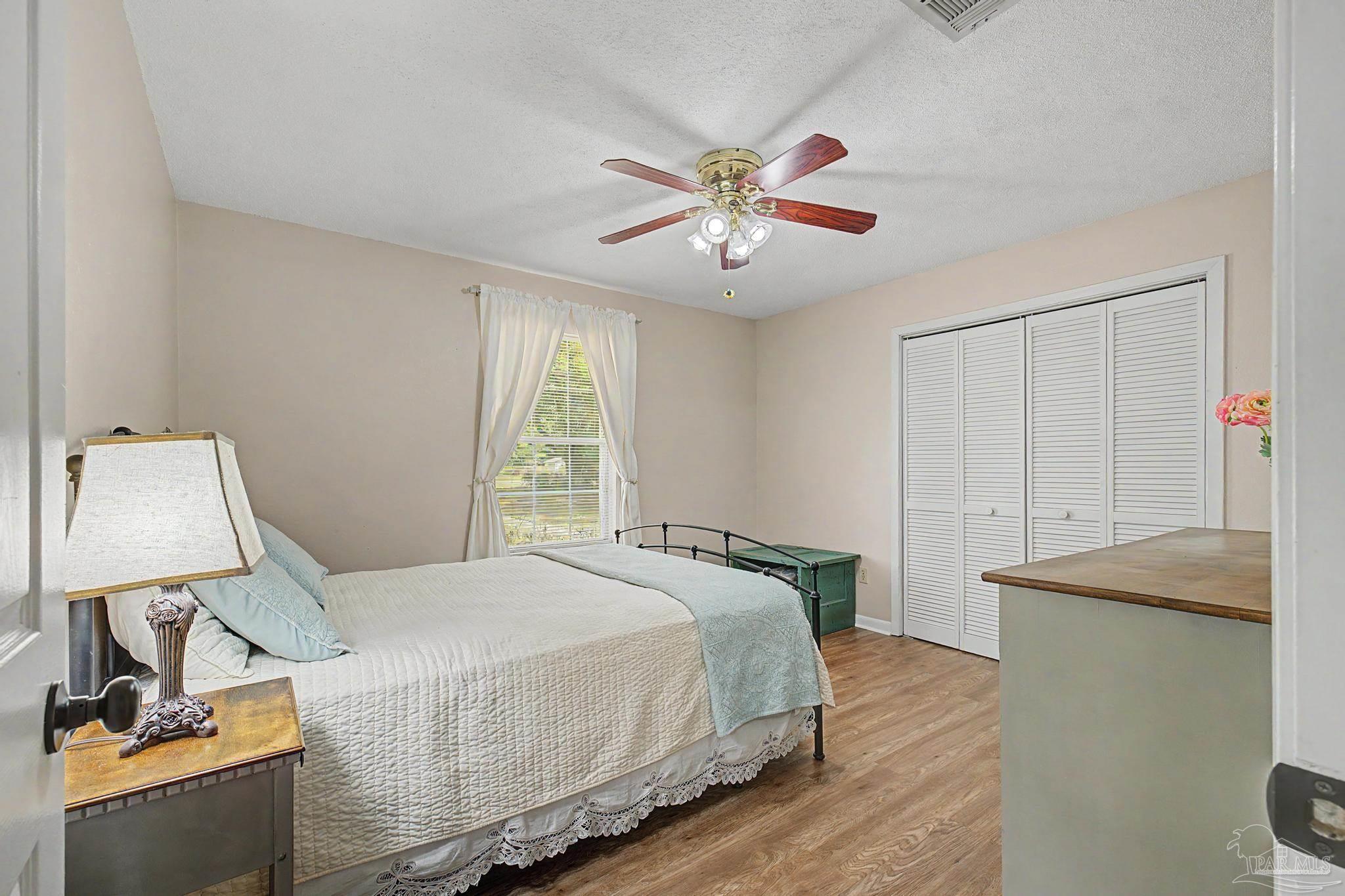 4959 Skipper Lane Pace, FL 32571 - Photo 24 of 51 a bedroom with a bed and a chandelier