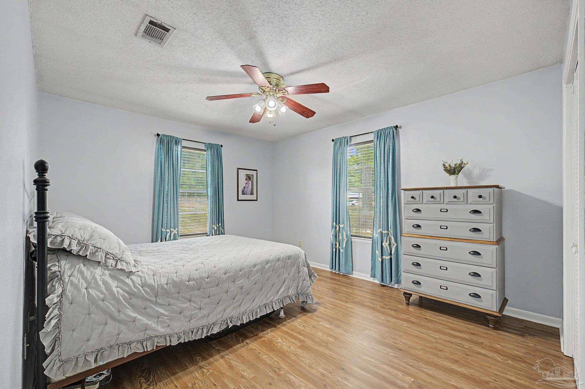 4959 Skipper Lane Pace, FL 32571 - Photo 26 of 51 a bedroom with a large bed and a chandelier