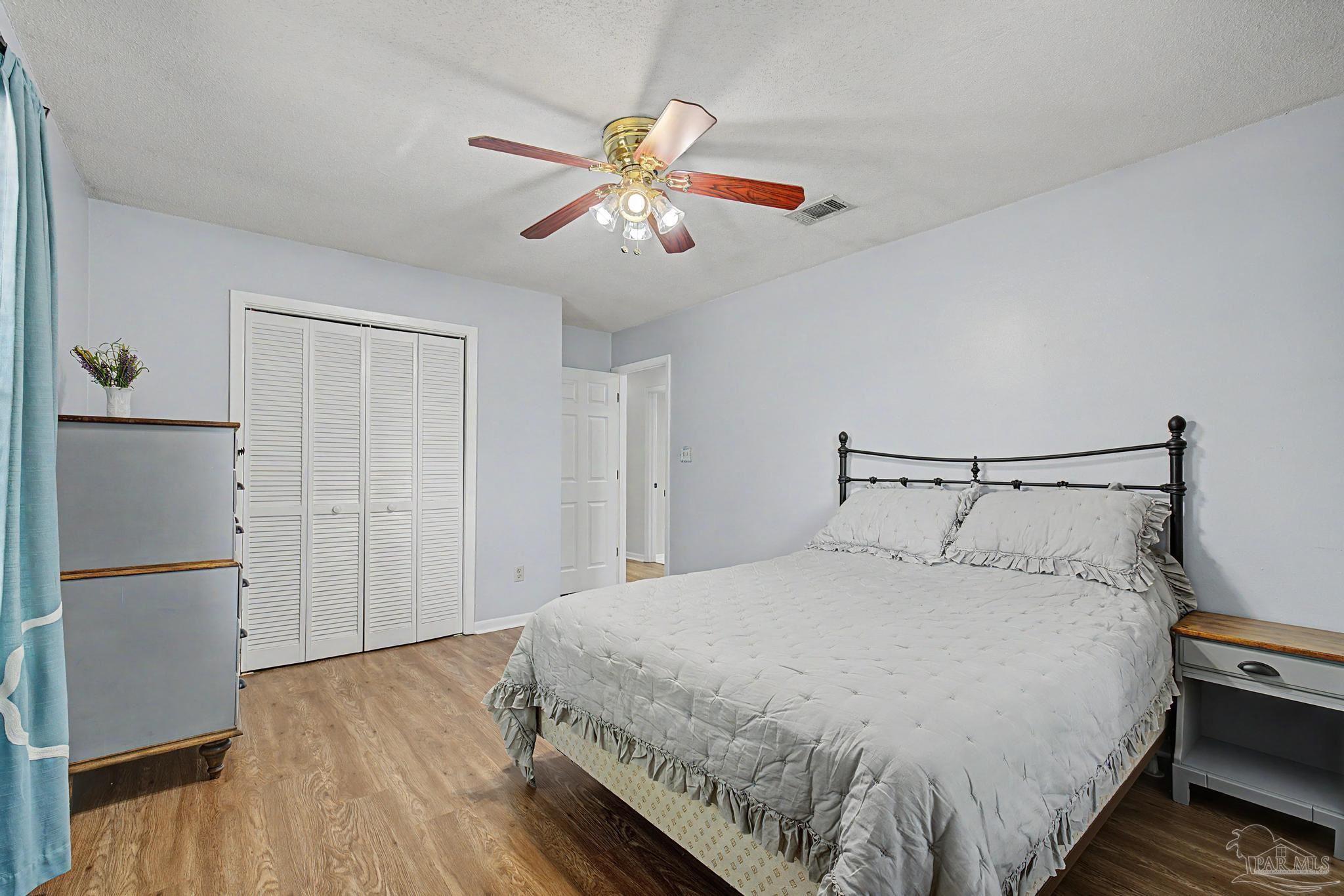 4959 Skipper Lane Pace, FL 32571 - Photo 27 of 51 a bedroom with a bed and a chandelier